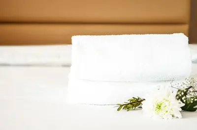 a stack of towels and flowers on a table at MStar Hotel in Kitimat