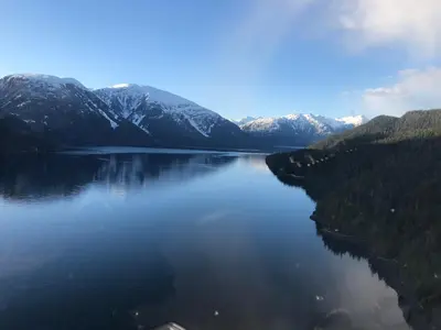 a view of a lake with snow covered mountains at Stewart Mountain Lodge in Stewart