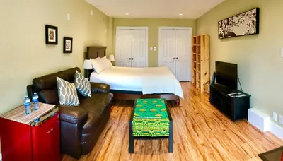 a hotel room with a bed and a couch and a television at Bay View House in Vancouver