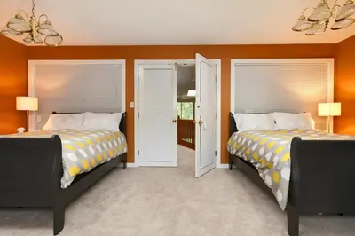 two beds in a room with orange walls at Muchen Villa in Delta