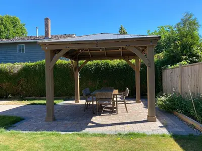 a wooden pavilion with a table and chairs on a patio at Richmond Vancouver Airport Comfy Home in Richmond