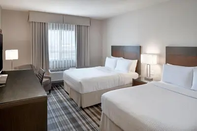 a hotel room with two beds and a desk at Fairfield Inn & Suites by Marriott Airdrie in Airdrie