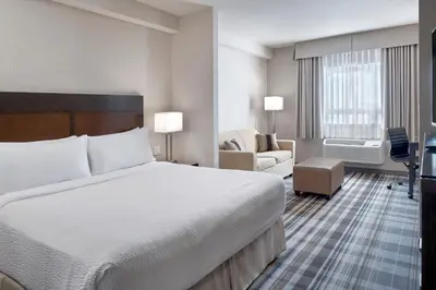 a hotel room with a bed and a living room at Fairfield Inn & Suites by Marriott Airdrie in Airdrie