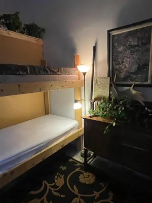 a bedroom with two bunk beds and a desk with a lamp at Nanimahoo's Sled N'Bed in Malakwa