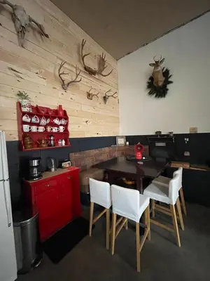 a kitchen with a table and some antlers on the wall at Nanimahoo's Sled N'Bed in Malakwa