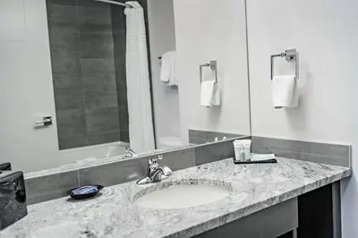 a bathroom with a sink and a large mirror at Park Inn by Radisson Edmonton Airport in Leduc