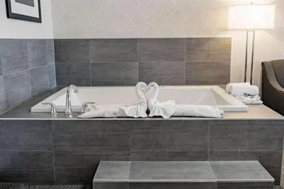 a bathroom with a tub with towels on it at Park Inn by Radisson Edmonton Airport in Leduc