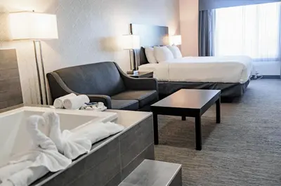 a hotel room with a bed and a bath tub at Park Inn by Radisson Edmonton Airport in Leduc