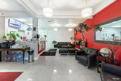 a waiting room with red walls and couches at Queens Hotel in New Westminster