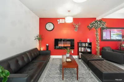 a living room with a couch and a red wall at Queens Hotel in New Westminster