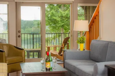 a living room with a couch and a table with wine glasses at The Cottages on Salt Spring Island in Ganges