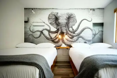 a room with two beds with an octopus on the wall at Crash Hotel Squamish in Squamish