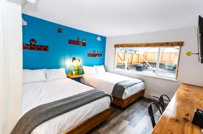 two beds in a room with blue walls at Crash Hotel Squamish in Squamish