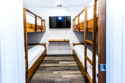 a room with bunk beds and a flat screen tv at Crash Hotel Squamish in Squamish