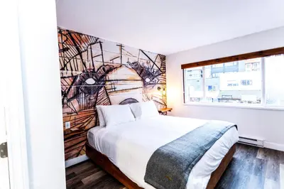 a bedroom with a bed with a mural on the wall at Crash Hotel Squamish in Squamish