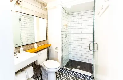 a bathroom with a toilet and a sink and a shower at Crash Hotel Squamish in Squamish