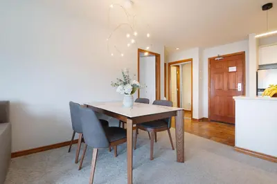 a dining room table with chairs and a vase of flowers at Aspens Mountain Side Resort in Whistler