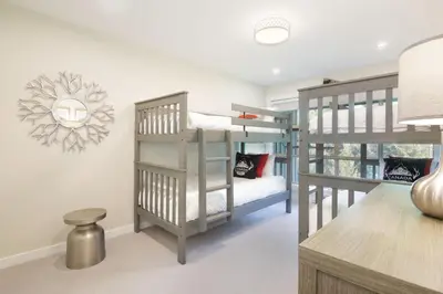 a room with two bunk beds and a desk at Aspens Mountain Side Resort in Whistler