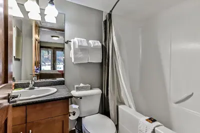 a bathroom with a toilet and a sink and a mirror at Spacious Mountain 2 Bedroom with Hot tub managed by Little Sister Getaways in Canmore