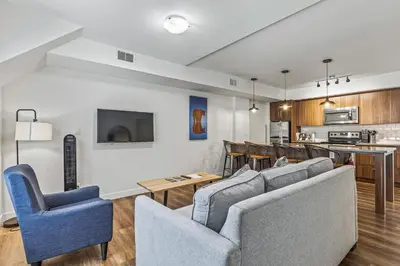 a living room with a couch and chairs and a kitchen at Basecamp Resorts Canmore in Canmore