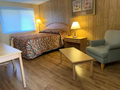 a hotel room with a bed and a chair at Green View Motel and RV Park in Greenwood