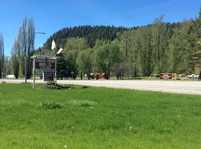 a sign on the side of a road with a playground at Green View Motel and RV Park in Greenwood