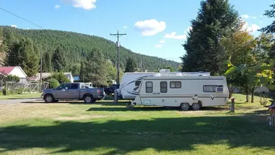 a rv and a truck parked in a field at Green View Motel and RV Park in Greenwood