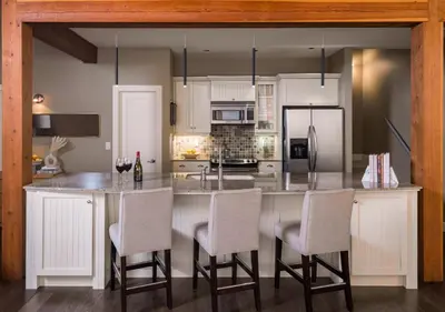 a kitchen with a large island with bar chairs at Outback Lakeside Vacation Homes in Vernon