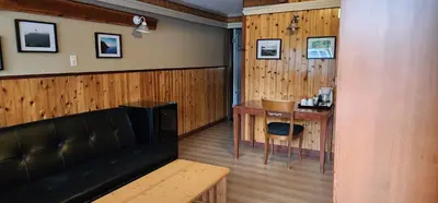 a living room with a table and a desk at Meares Vista Inn in Tofino