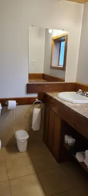 a bathroom with a sink and a toilet and a mirror at Meares Vista Inn in Tofino