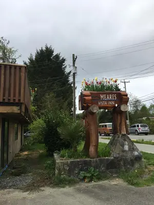 a sign for akers wolf inn on a street at Meares Vista Inn in Tofino