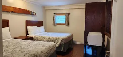a hotel room with two beds and a window at Meares Vista Inn in Tofino