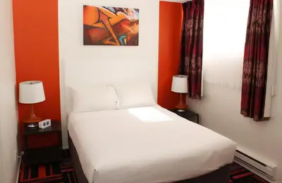 a bedroom with a white bed and two lamps at Hotel Zed Kelowna in Kelowna