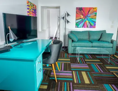 a living room with a blue desk and a couch at Hotel Zed Kelowna in Kelowna