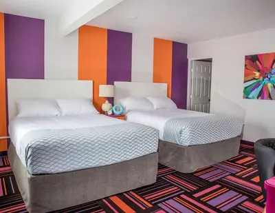 two beds in a room with colorful walls at Hotel Zed Kelowna in Kelowna