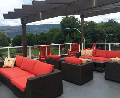 a patio with chairs and couches on a roof at Hotel Zed Kelowna in Kelowna