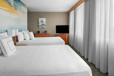 a hotel room with two beds and a flat screen tv at Courtyard by Marriott Edmonton Downtown in Edmonton