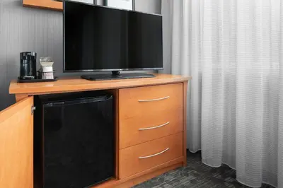 a flat screen tv on a dresser with a television on it at Courtyard by Marriott Edmonton Downtown in Edmonton