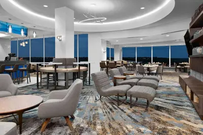 a hotel lobby with tables and chairs and windows at Courtyard by Marriott Edmonton Downtown in Edmonton