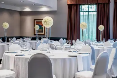 a room filled with tables and chairs with white tablecloths at Fairfield Inn & Suites by Marriott Kelowna in Kelowna