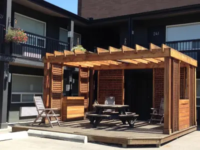 a wooden pergola with a picnic table on a patio at Centro Motel in Calgary