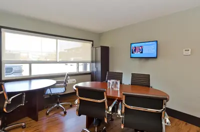 a conference room with a table and chairs and a tv at Centro Motel in Calgary