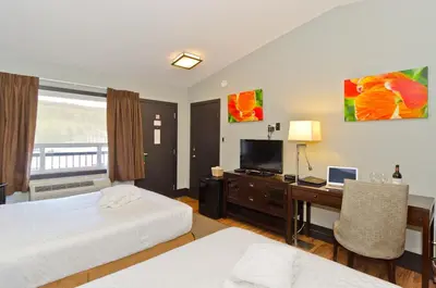 a hotel room with two beds and a desk with a computer at Centro Motel in Calgary