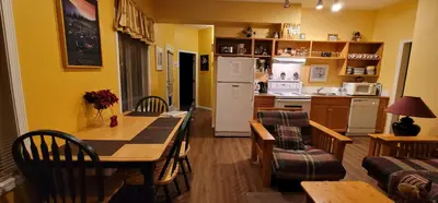 a kitchen and living room with a table and a refrigerator at Vacation Homes by The Bulldog- Berker's Suite A in Silver Star