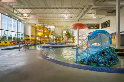 a large indoor pool with a slide and slides at Deerfoot Inn and Casino in Calgary