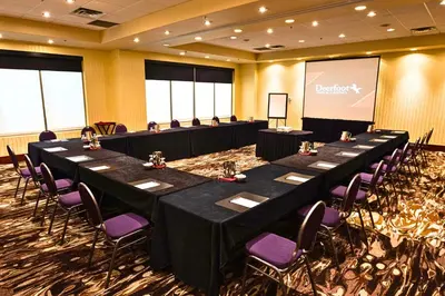 a conference room with long tables and purple chairs at Deerfoot Inn and Casino in Calgary