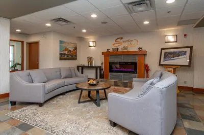 a living room with couches and a table and a fireplace at Service Plus Inns and Suites Calgary in Calgary
