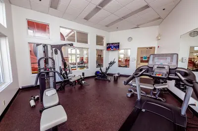 a gym with several treadmills and machines in a room at Service Plus Inns and Suites Calgary in Calgary