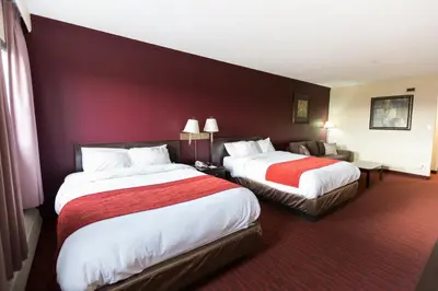 a hotel room with two beds and a red wall at Argyll Plaza Hotel in Edmonton