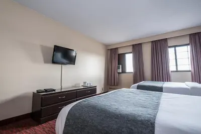 a hotel room with two beds and a flat screen tv at Argyll Plaza Hotel in Edmonton